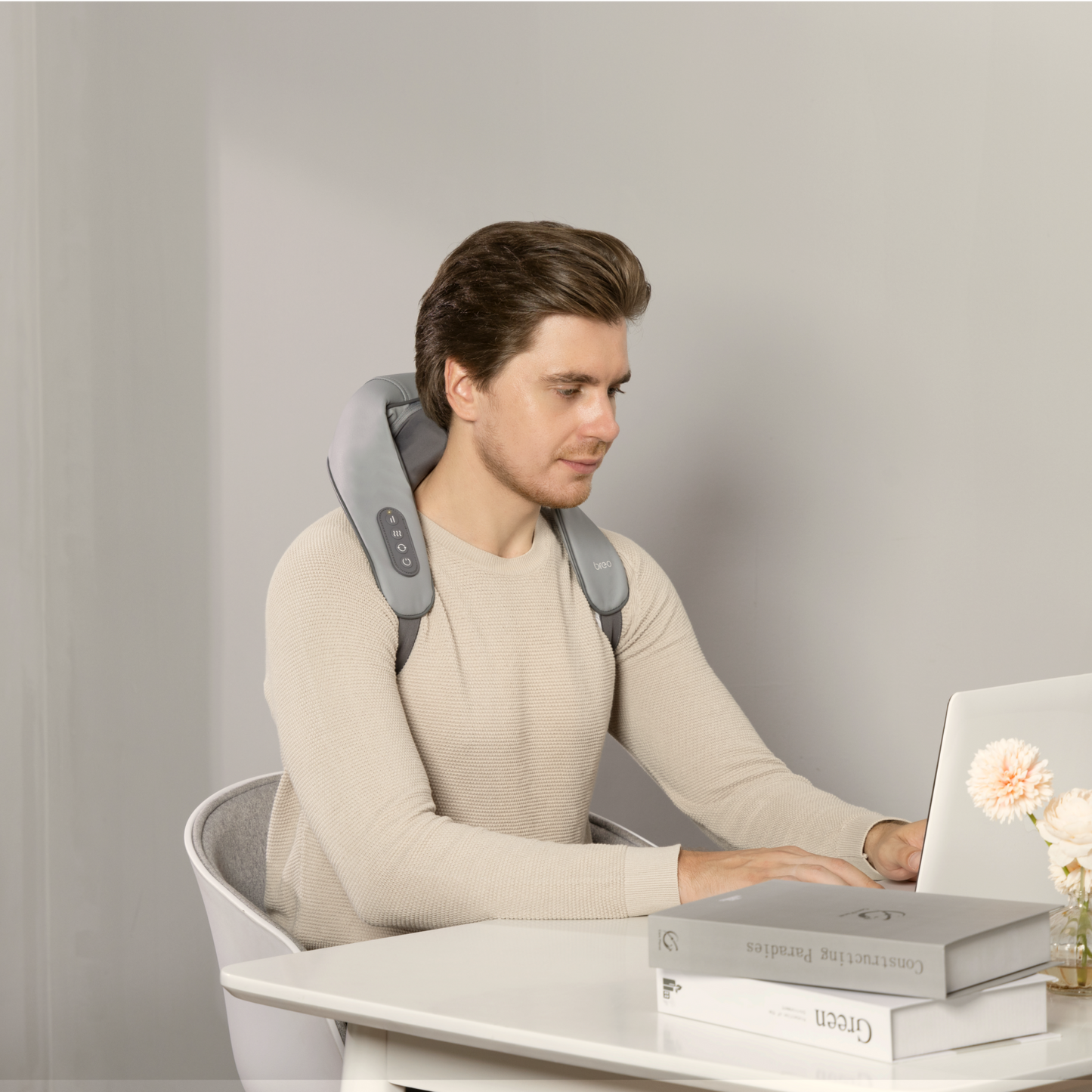 Breo N5 Mini neck and shoulder massager in use, providing stress relief while working on a laptop.