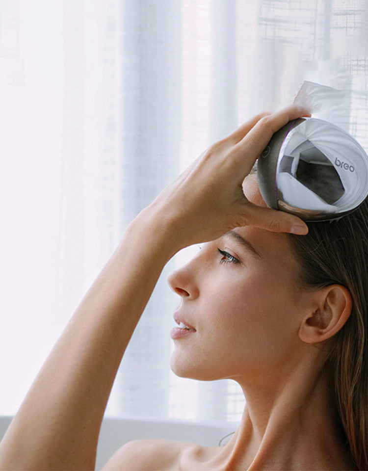 Woman using Breo Scalp Mini Pro for scalp massage. Breo massager promoting relaxation and hair growth.
